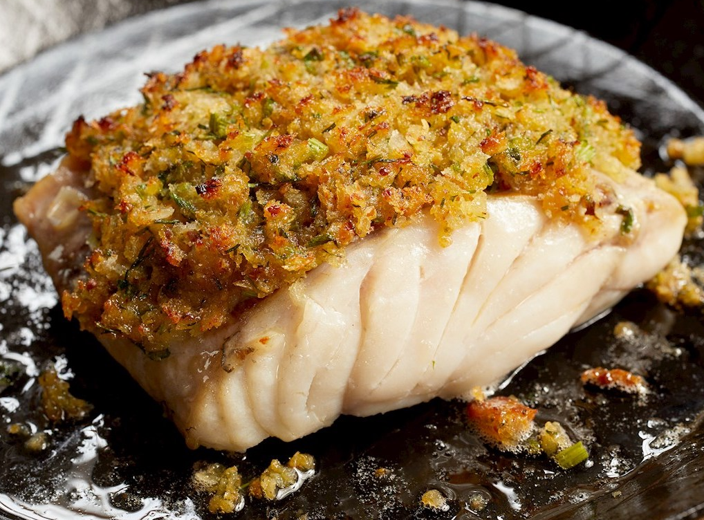 Baked fish fillets covered in garlic and lemon-infused bread crumbs