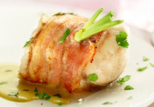 Monkfish wrapped in bacon with a buttery sauce